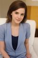 A woman in a blue suit sitting on a white couch.