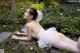 A woman in a wedding dress laying on the ground.