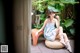 A woman sitting on a chair in a garden eating a flower.