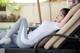 A woman laying on a lounge chair with her legs crossed.