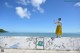 A woman standing on top of a wall next to the ocean.