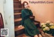 a woman in a green dress sitting on some stairs