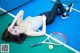 A woman laying on a tennis court with a racket and ball.