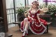 A woman in a red and white dress sitting on a bench.