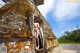 A naked woman standing in the doorway of an old building.